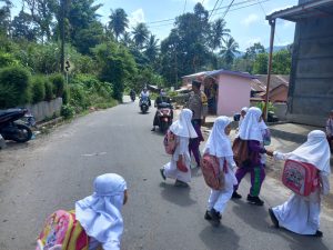 Peduli Pelajar, Bhabinkamtibmas Polsek Hutaimbaru Bantu Sebrangkan Siswa ke Sekolah