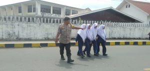 Bhabinkamtibmas Polsek Hutaimbaru Bantu Seberangkan Siswa Sekolah