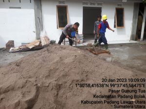 Meringankan Beban, Bhabinkamtibmas Polsek Padang Bolak Bantu Pekerja Bangunan “Menyodok” Pasir