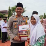 Kapolres Tapsel, AKBP Imam Zamroni, menyerahkan Piala dan hadiah ke salah satu santriwati berprestasi pada peringatan Hari Santri Nasional di Kabupaten Paluta tahun 2023