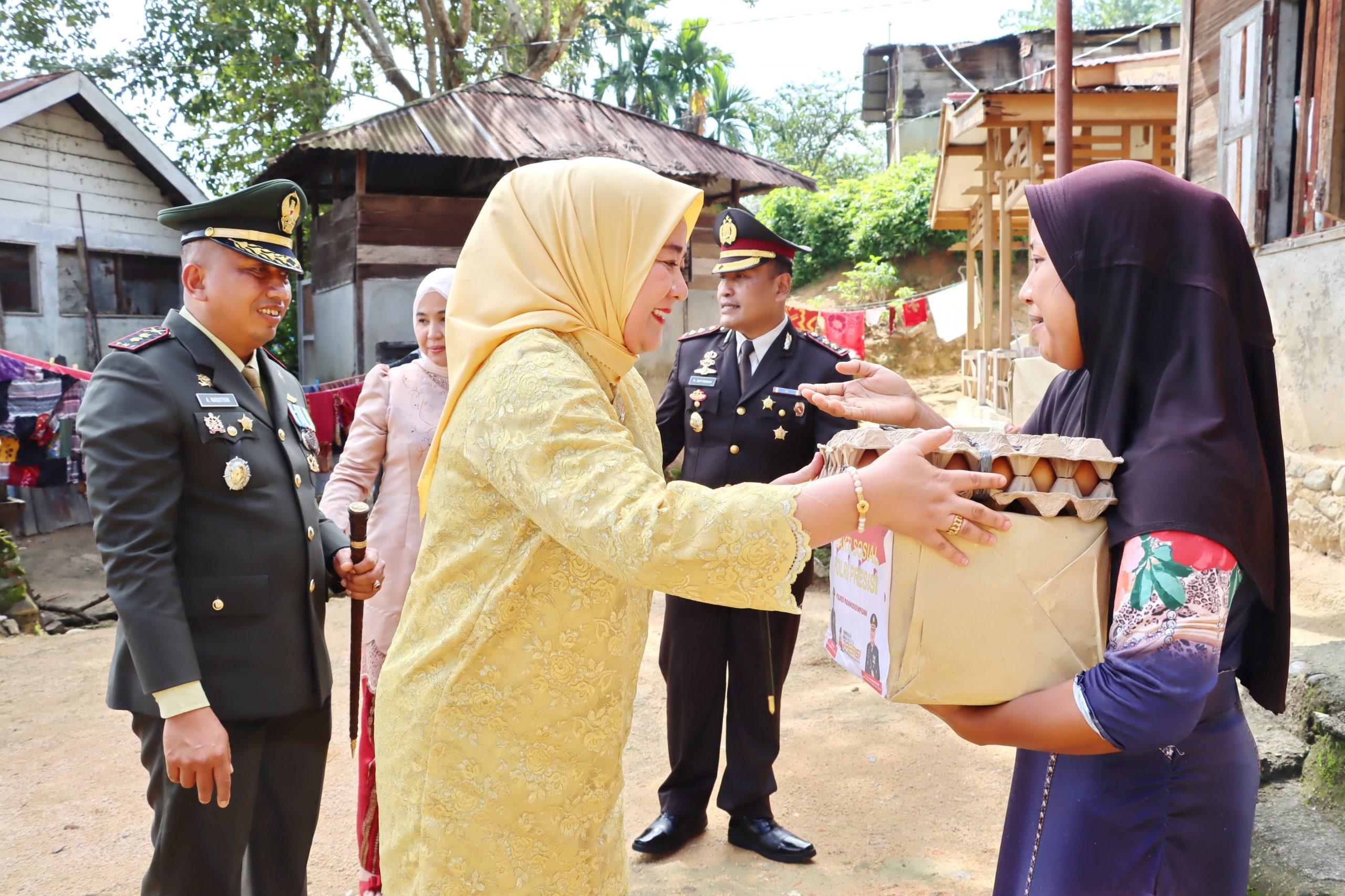 Ketua Persit KCK Cabang XLV, Ny Ayu Amrizal Nasution, serahkan bantuan sembako ke warga