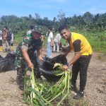 Kanit Reskrim Polsek Batang Toru, Ipda Ery J Situmorang (kanan) dan Babinsa Koramil 01/Batang Toru, Pelda J Giawa, kompak membersihkan sampah saat aksi pelestarian lingkungan yang diinisiasi PT AR