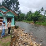 Kanit II Ekonomi Sat Reskrim Polres Tapsel, Ipda Ilham P Nasution, saat mengecek lokasi Rumah yang hanyut akibat tersapu arus Sungai yang besar saat banjir melanda di Desa Hapesong Lama, Kecamatan Batang Toru