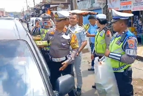 Kasat Lantas Polres Tapsel, AKP Danil Saragih, berbagi nasi kotak ke pengguna Jalan yang mematuhi peraturan lalu lintas sebagai reward dalam program Jumat Berkah