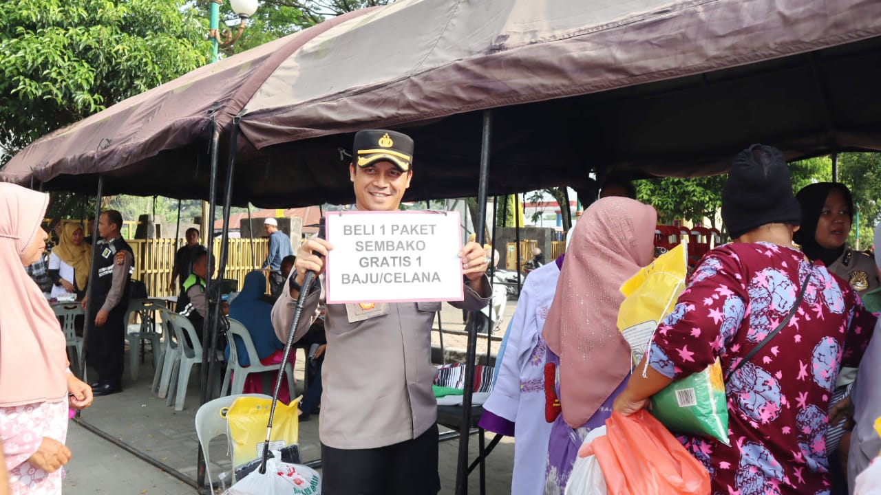 Keceriaan Kapolres Tapsel, AKBP Yasir Ahmadi, yang ikut terjun langsung membaur bersama masyarakat seraya menunjukkan beli sembako murah gratis baju/celana di Pasar Murah di Halaman Masjid Gunung Tua
