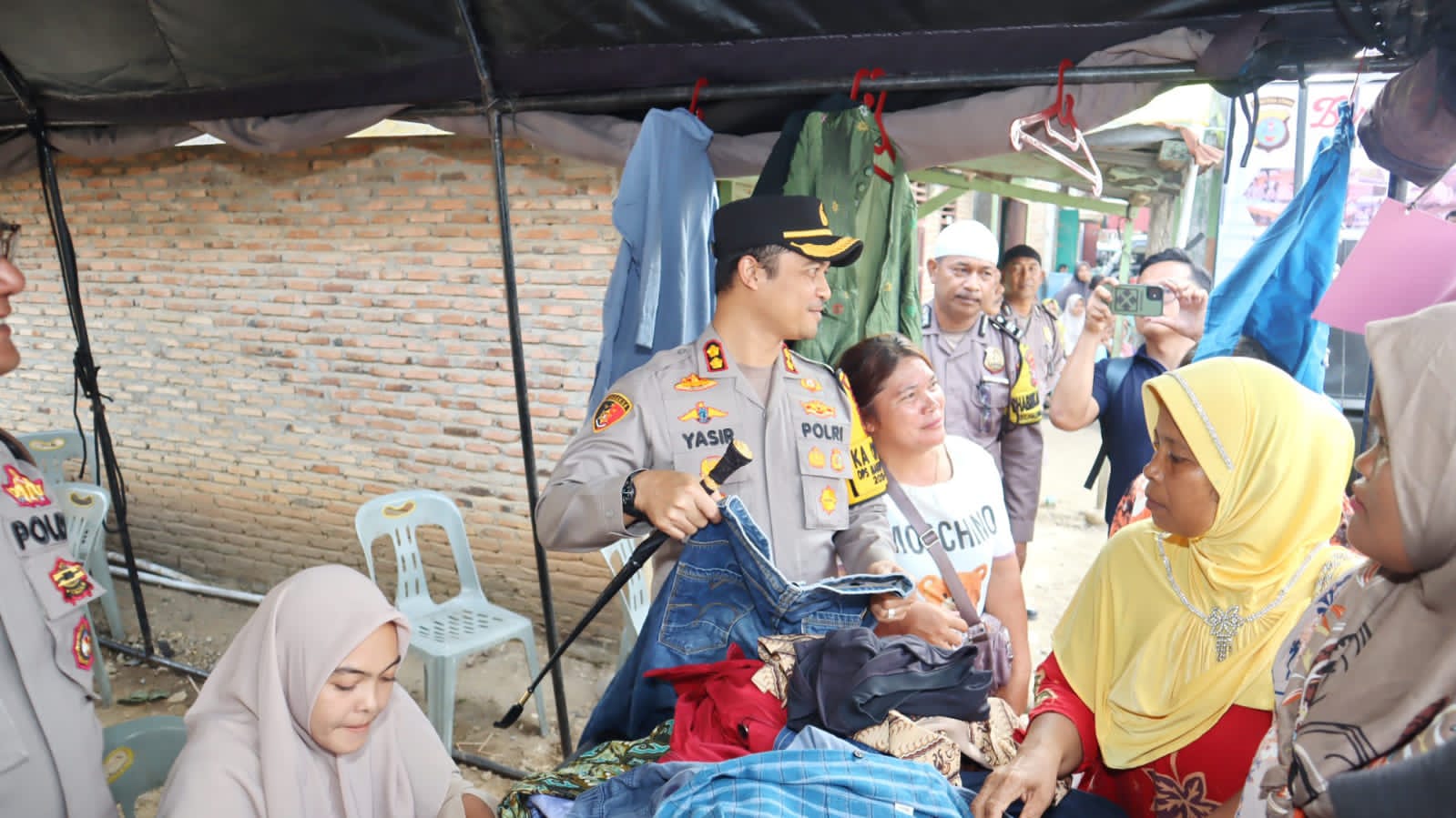 Kapolres Tapsel, AKBP Yasir Ahmadi, memberikan pakaian gratis kepada setiap masyarakat yang membeli sembako murah di program Ramadan Berkah Polres Tapsel