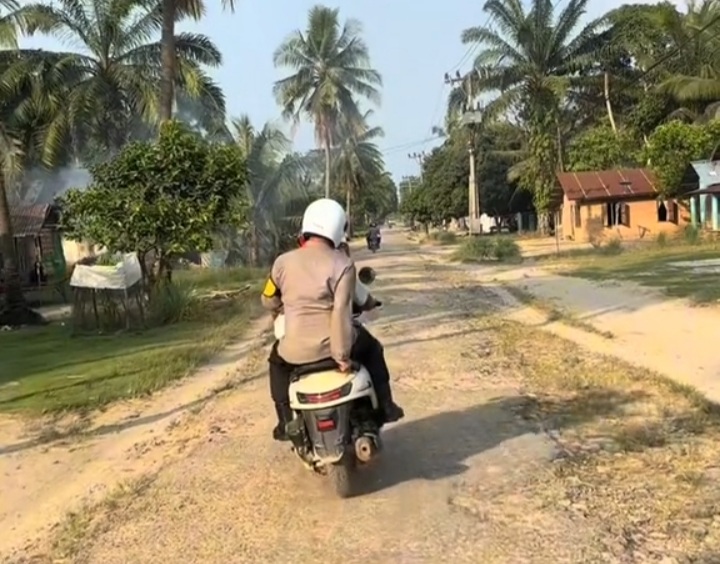 Menyusuri perkampungan masyarakat, Kapolres Tapsel, AKBP Yasir Ahmadi, naik motor membawa sembako untuk bantu warga Pra Sejahtera