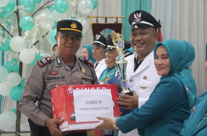 Kapolsek Padang Bolak, AKP Harun Manurung, menyerahkan bingkisan ke salah satu Kepala Desa karena meraih Juara III tertib administrasi saat HKG PKK ke-52 Kabupaten Paluta
