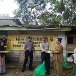 Personel Polsek Batang Toru menyerahkan makan siang gratis berupa nasi kotak dalam rangka program Jumat Berkah