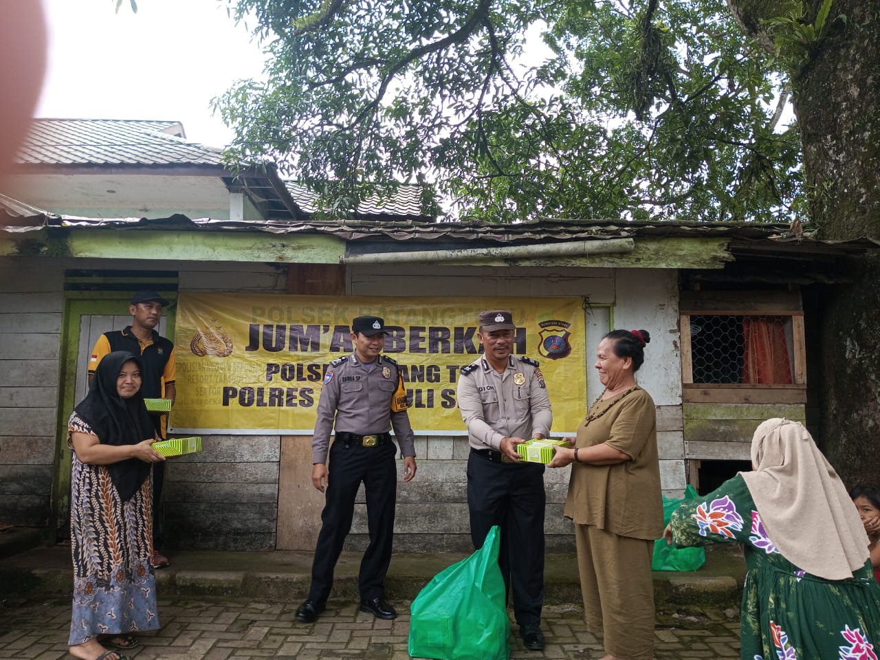 Personel Polsek Batang Toru menyerahkan makan siang gratis berupa nasi kotak dalam rangka program Jumat Berkah