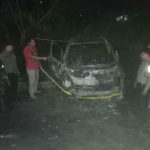 Personel Polsek Padang Bolak saat memasangi garis polisi di mobil yang dibakar
