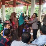 Kasi Humas, AKP Maria Marpaung, beri bingkisan ke salah satu masyarakat yang mengikuti program bertajuk gerakan Kapolres Tapsel Jelajah Huta di Desa Silangkitang, Kecamatan Aek Bilah