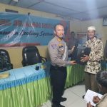 Kasat Lantas, AKP Danil Saragih, memberi souvenir ke masyarakat secara simbolis usai menyampaikan paparannya dalam gerakan Kapolres Tapsel Jelajah Huta