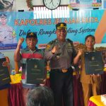 Kabag Log Polres Tapsel, Kompol Daulat MZ Harahap, bersama KBO Sat Reskrim, Iptu Aswin Manurung, usai menyerahkan souvenir ke perwakilan masyarakat dalam gerakan Kapolres Jelajah Huta
