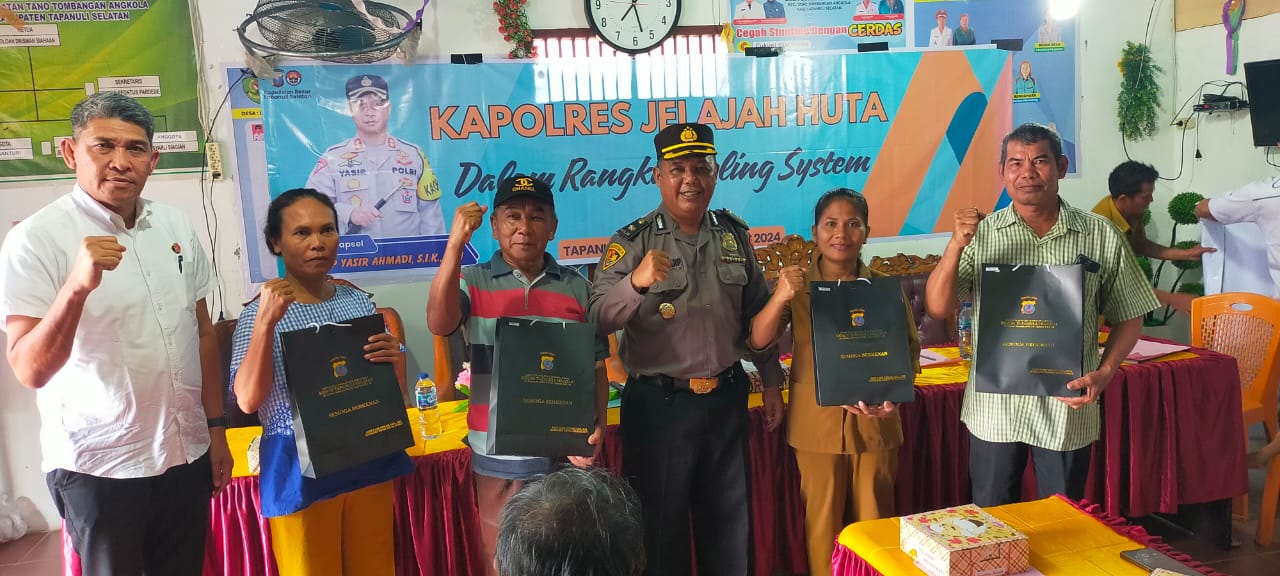 Kabag Log Polres Tapsel, Kompol Daulat MZ Harahap, bersama KBO Sat Reskrim, Iptu Aswin Manurung, usai menyerahkan souvenir ke perwakilan masyarakat dalam gerakan Kapolres Jelajah Huta