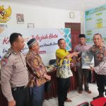 Kasi Propam Polres Tapsel, AKP R Trihardjanto, menyerahkan souvenir ke perwakilan masyarakat di sela gerakan Kapolres Jelajah Huta