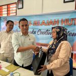 Kanit Tipiter Sat Reskrim Polres Tapsel, Ipda Ilham P Nasution, menyerahkan souvenir ke perwakilan masyarakat di sela gerakan Kapolres Jelajah Huta