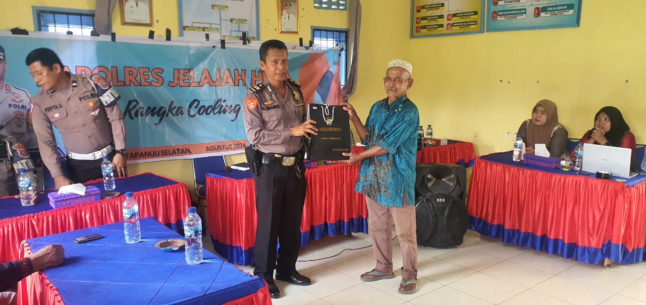 Kasium Polres Tapsel, Iptu Heri Sigiro, menyerahkan souvenir ke salah satu perwakilan masyarakat saat gerakan Kapolres Tapsel Jelajah Huta