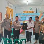 Kanit Gakkum Sat Lantas Polres Tapsel, Ipda Samuel Jefri Hutapea, bersama Waka Polsek Batang Toru, Iptu Taufik Simanullang, saat menyerahkan souvenir ke perwakilan perangkat Desa yang hadir dalam gerakan Kapolres Jelajah Huta