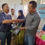 KBO Sat Resnarkoba Polres Tapsel, Ipda TP Saragih, saat menyerahkan souvenir ke perangkat Desa Siuhom di sela gerakan Kapolres Jelajah Huta