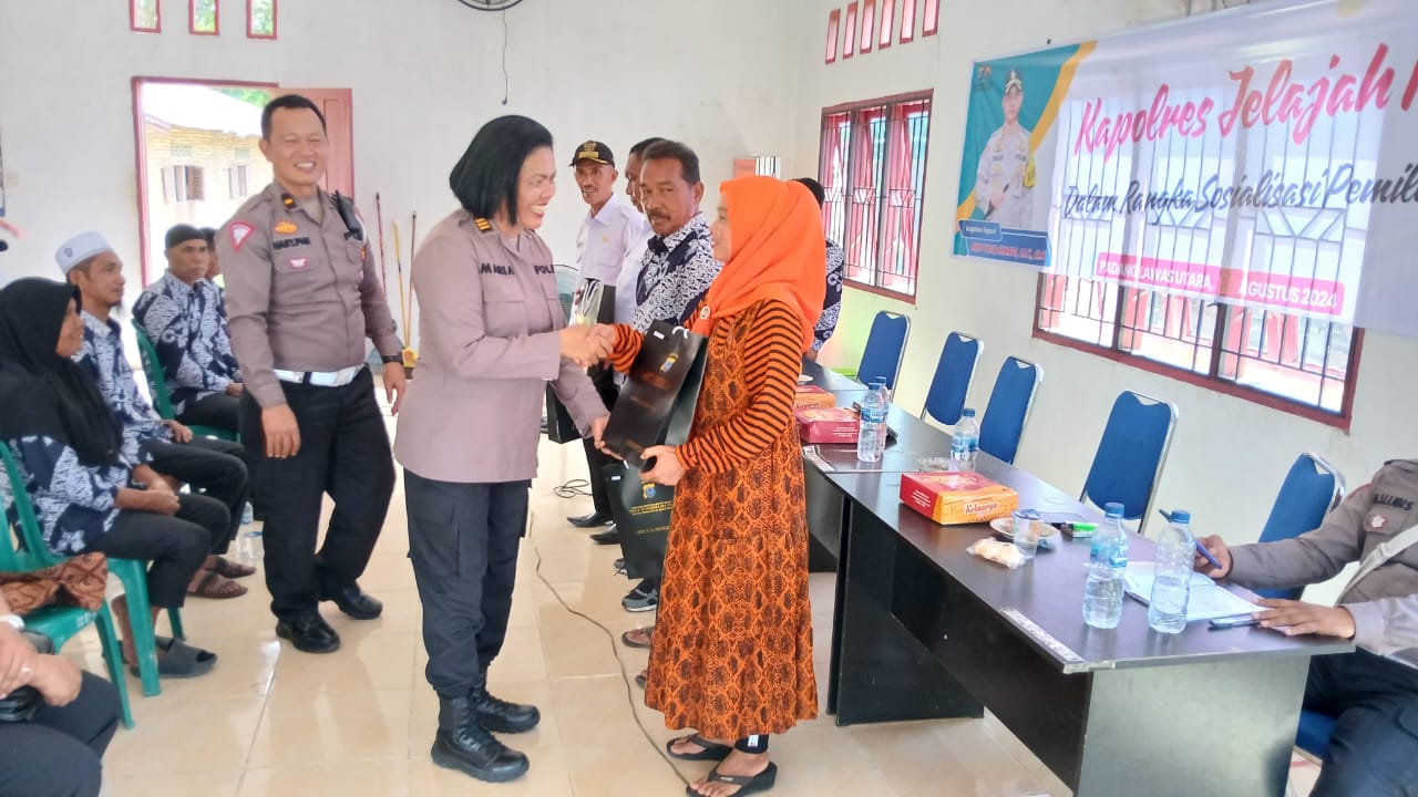 Kasi Humas Polres Tapsel, AKP Maria Marpaung, bersama KBO Sat Lantas, Ipda Hary Agus Pohan, saat menyerahkan souvenir ke perwakilan masyarakat di sela gerakan Kapolres Jelajah Huta