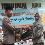 Kabag SDM Polres Tapsel, AKP Sumanto Naibaho, saat menyerahkan souvenir ke perwakilan masyarakat di sela gerakan Kapolres Jelajah Huta