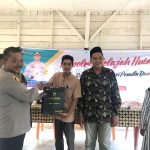 Kapolsek Dolok, Iptu Suhardi, saat menyerahkan souvenir ke perwakilan masyarakat di sela gerakan Kapolres Tapsel Jelajah Huta di Kabupaten Paluta