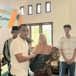 Kanit Tipiter Sat Reskrim Polres Tapsel, Ipda Ilham P Nasution, saat menyerahkan souvenir ke perwakilan masyarakat di sela gerakan Kapolres Jelajah Huta