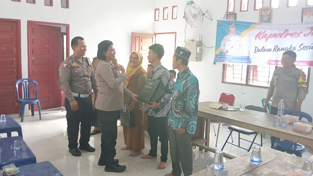 Kasi Humas Polres Tapsel, AKP Maria Marpaung, saat menyerahkan souvenir ke perwakilan perangkat Desa Gunung Martua yang hadir dalam gerakan Kapolres Jelajah Huta