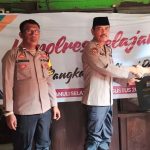 Kabag SDM Polres Tapsel, AKP Sumanto Naibaho, saat menyerahkan souvenir ke perwakilan masyarakat di sela gerakan Kapolres Jelajah Huta