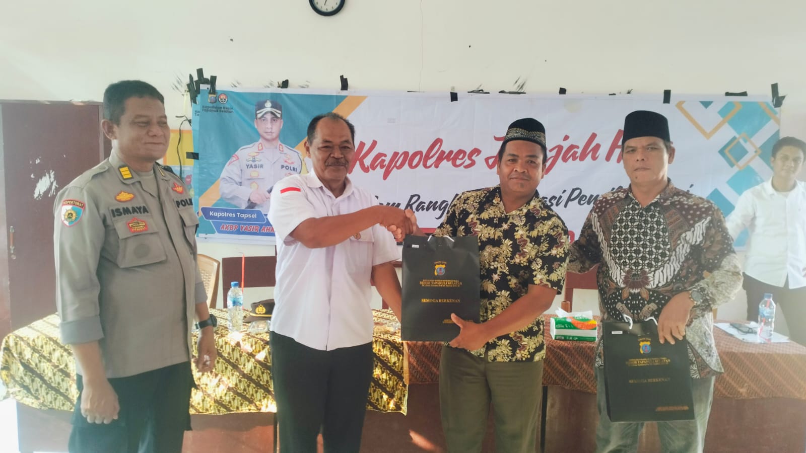Kasiwas Polres Tapsel, AKP Ismaya, didampingi Kanit I Sat Intelkam, Iptu Titus Dwioko, saat menyerahkan souvenir ke masyarakat di sela gerakan Kapolres Jelajah Huta