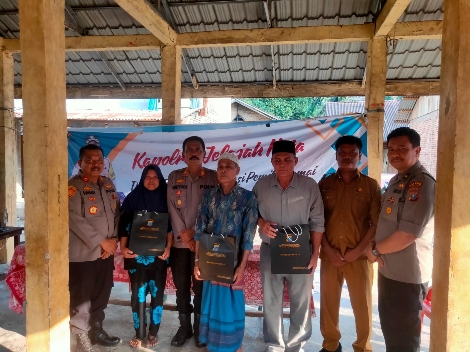 Kasat Binmas Polres Tapsel, AKP Eka Wahyudi, bersama Kapolsek Dolok, Iptu Suhardi, dan Ka SPKT, Ipda Irwan H Sarumpaet, usai menyerahkan souvenir kepada perwakilan masyarakat di sela gerakan Kapolres Jelajah Huta