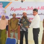 KBO Sat Reskrim Polres Tapsel, Iptu Aswin Manurung, saat menyerahkan souvenir kepada perwakilan masyarakat di sela gerakan Kapolres Jelajah Huta