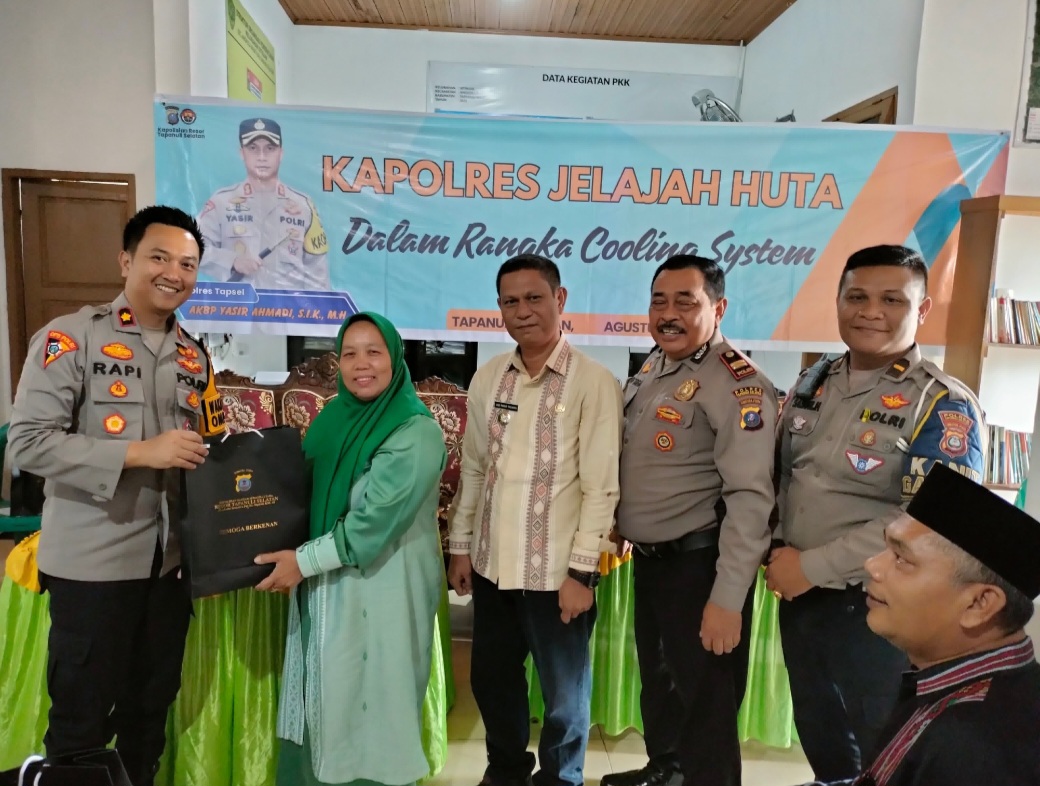 Waka Polres Tapsel, Kompol Rapi Pinakri, didampingi Kapolsek Batang Toru, Iptu RN Tarigan, dan lainnya, saat menyerahkan souvenir ke perwakilan masyarakat di sela gerakan Kapolres Jelajah Huta