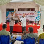 Kasat Binmas Polres Tapsel, AKP Eka Wahyudi, didampingi Ka SPKT, Ipda Irwan H Sarumpaet, usai menyerahkan souvenir ke perwakilan masyarakat di sela gerakan Kapolres Jelajah Huta
