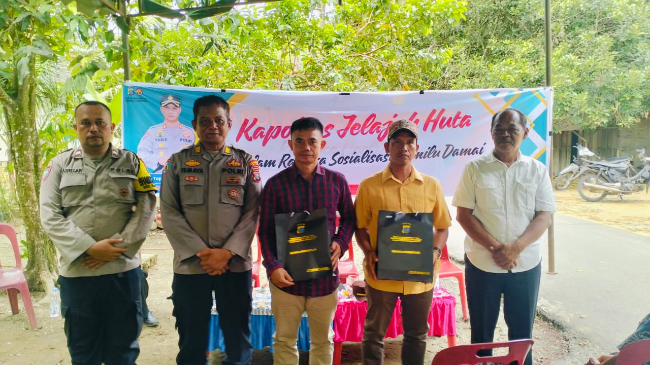 Kasiwas Polres Tapsel, AKP Ismaya, bersama Kanit I Sat Intelkam, Iptu Titus Dwioko, usai menyerahkan souvenir ke perwakilan masyarakat di sela kegiatan gerakan Kapolres Jelajah Huta