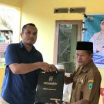 Kasat Intelkam Polres Tapsel, Iptu Oloan Lubis, saat menyerahkan souvenir ke perwakilan perangkat Desa Sungai Datar yang hadir dalam gerakan Kapolres Jelajah Huta