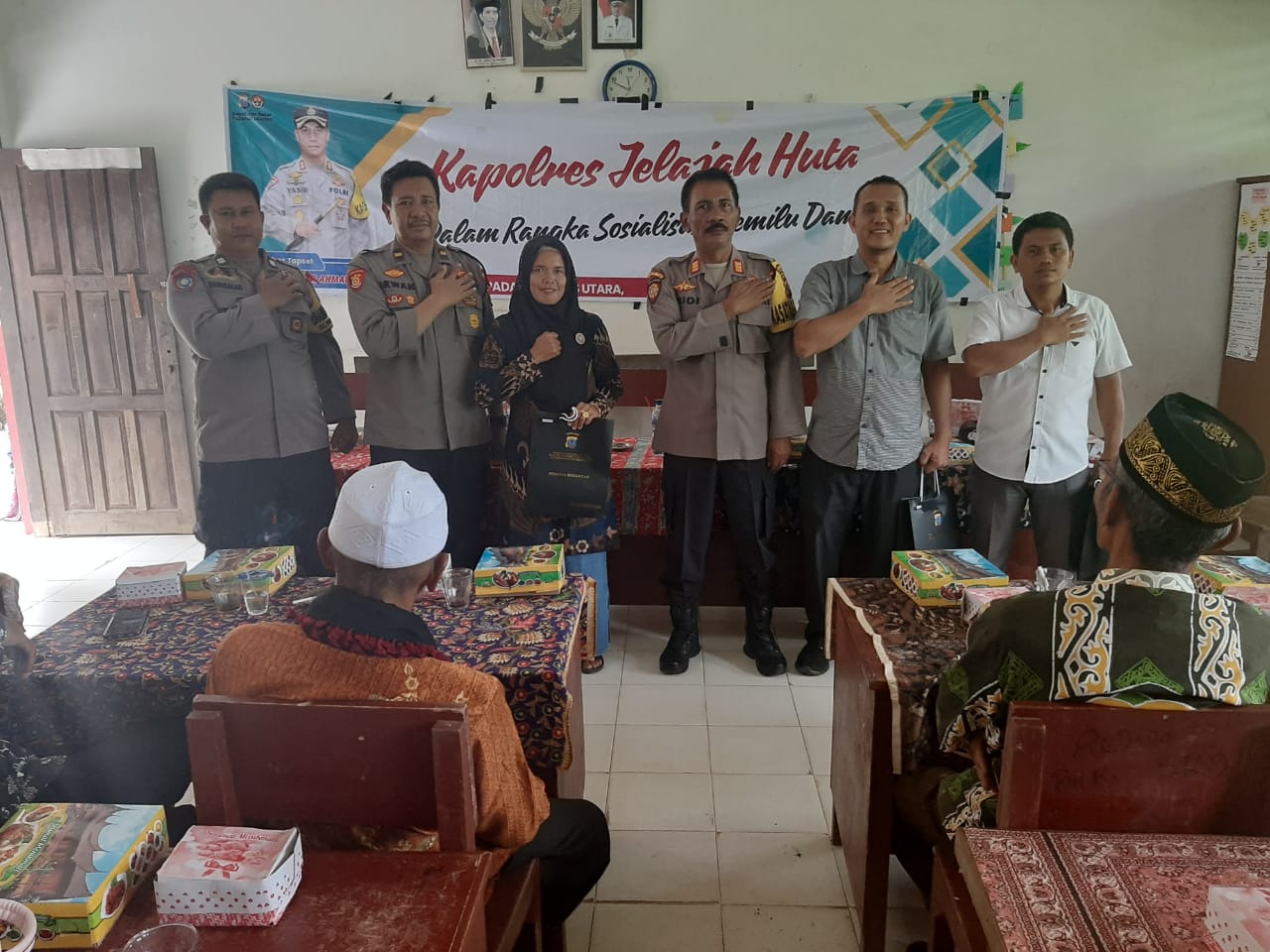 Kasat Binmas Polres Tapsel, AKP Eka Wahyudi, bersama Ka SPKT, Ipda Irwan H Sarumpaet, usai menyerahkan souvenir ke perwakilan masyarakat di sela gerakan Kapolres Jelajah Huta