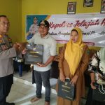 Kasi Propam Polres Tapsel, AKP R Triharjanto, saat menyerahkan souvenir ke perangkat Desa dan perwakilan masyarakat di sela gerakan Kapolres Jelajah Huta