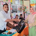 Kanit Tipiter Sat Reskrim Polres Tapsel, Ipda Ilham P Nasution, saat menyerahkan souvenir ke masyarakat di sela gerakan Kapolres Jelajah Huta