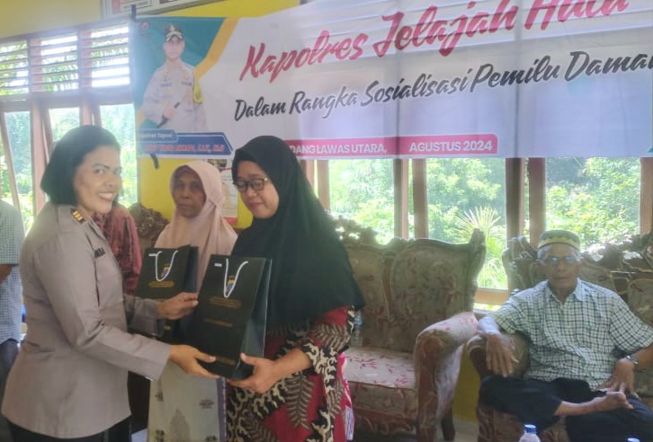 Kasi Humas Polres Tapsel, AKP Maria Marpaung, saat serahkan souvenir ke perwakilan masyarakat di sela gerakan Kapolres Jelajah Huta