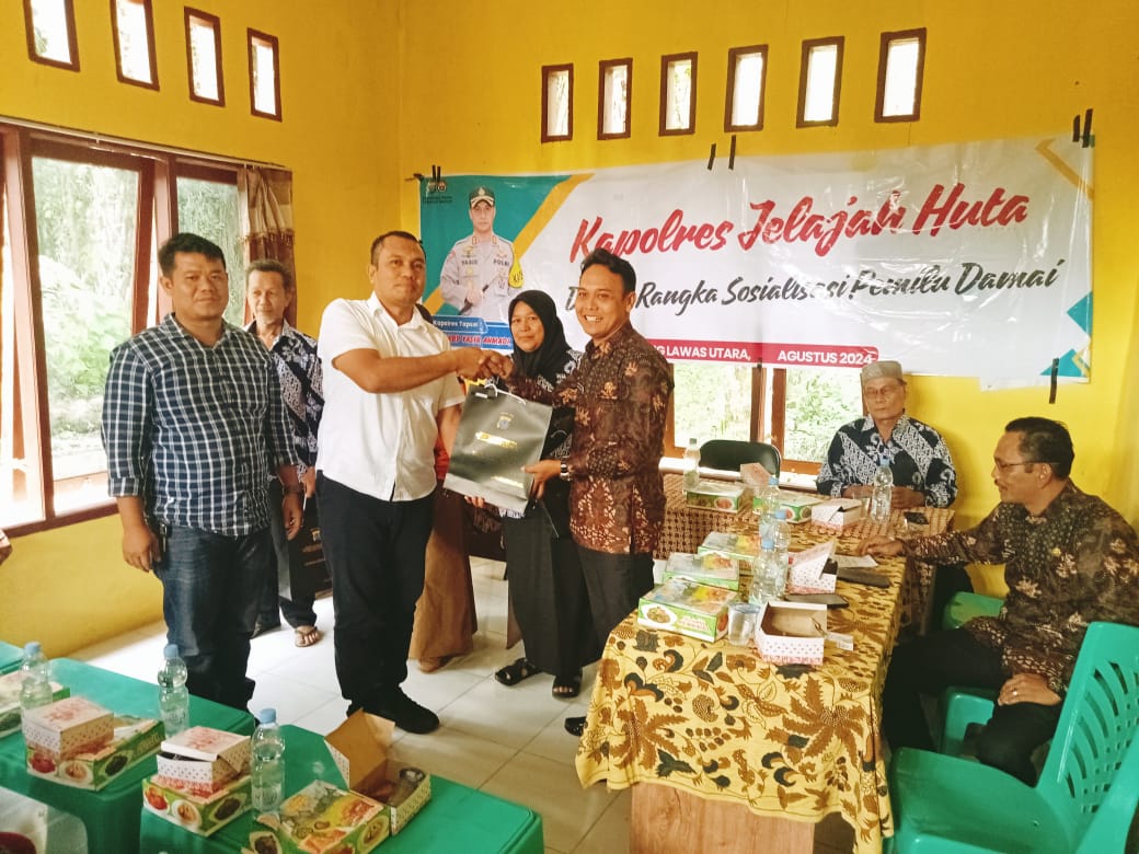 Kasat Intelkam Polres Tapsel, Iptu Oloan Lubis, saat menyerahkan souvenir ke perwakilan masyarakat di sela gerakan Kapolres Jelajah Huta