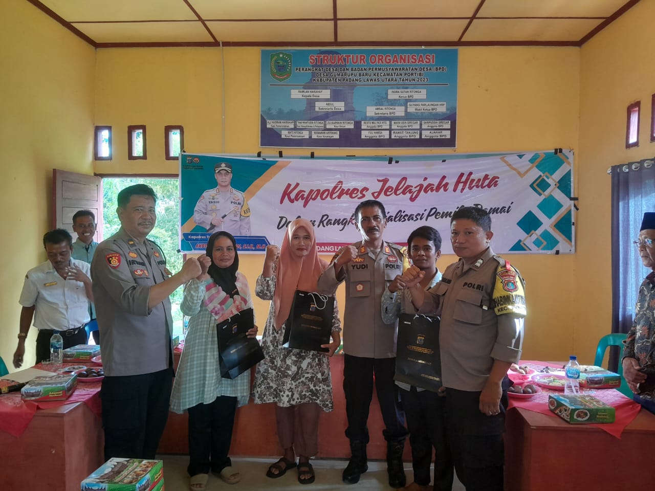 Kasat Binmas Polres Tapsel, AKP Eka Wahyudi, didampingi Ka SPKT, Ipda Irwan Sarumpaet, usai menyerahkan souvenir ke perwakilan masyarakat di sela gerakan Kapolres Jelajah Huta