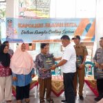 Kanit I Pidum Sat Reskrim Polres Tapsel, Ipda Maraden Hutabarat, saat menyerahkan souvenir ke perwakilan masyarakat di sela gerakan Kapolres Jelajah Huta