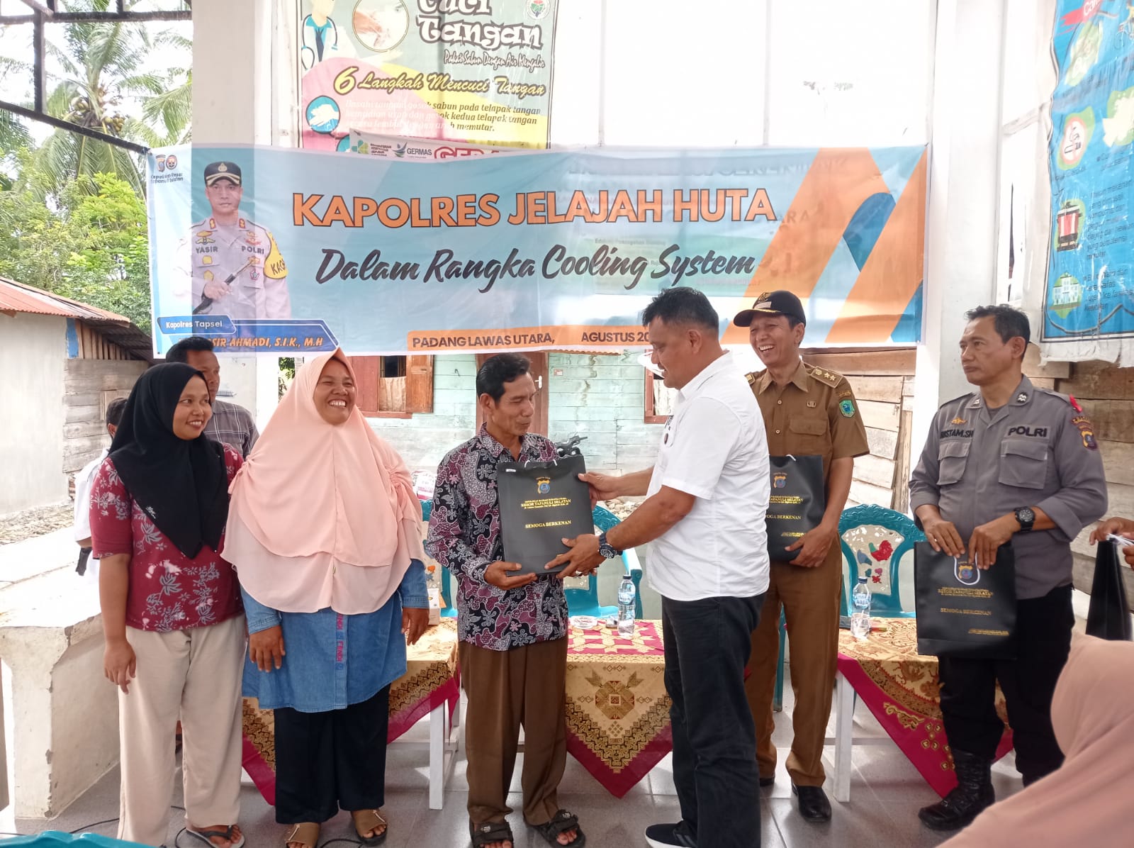 Kanit I Pidum Sat Reskrim Polres Tapsel, Ipda Maraden Hutabarat, saat menyerahkan souvenir ke perwakilan masyarakat di sela gerakan Kapolres Jelajah Huta