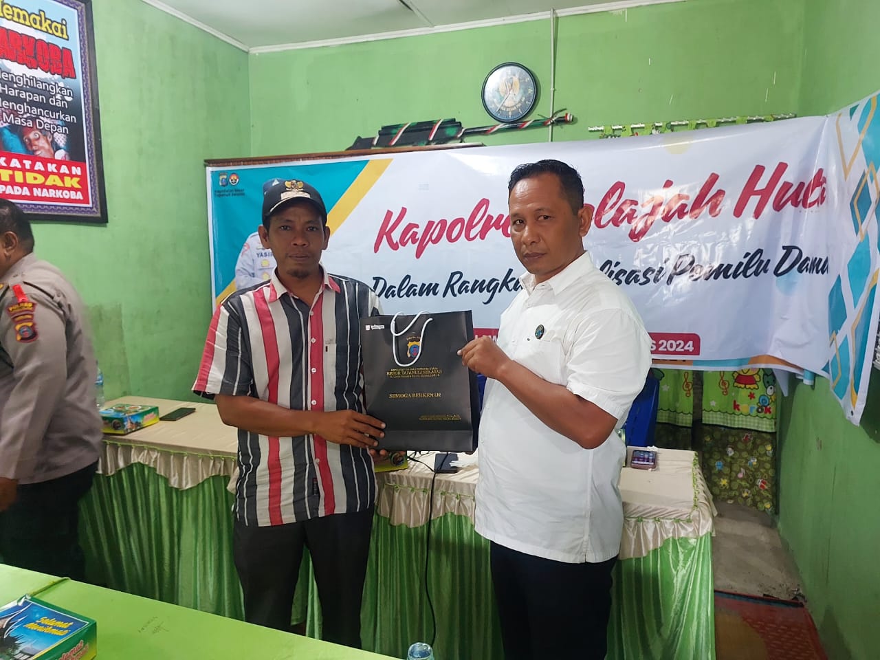 Kasat Resnarkoba Polres Tapsel, AKP Salomo Sagala, saat menyerahkan souvenir ke perwakilan masyarakat di sela gerakan Kapolres Tapsel Jelajah Huta di Kabupaten Paluta