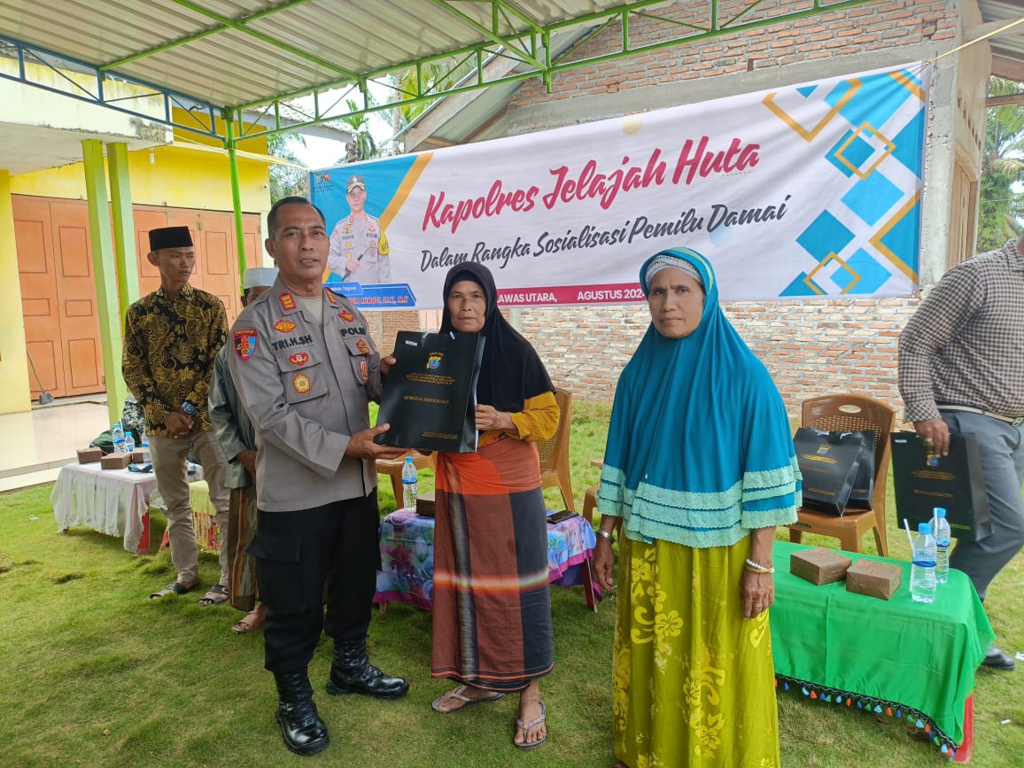 Kasi Propam Polres Tapsel, AKP R Triharjanto, saat menyerahkan souvenir ke perwakilan masyarakat Kabupaten Padang Lawas Utara di sela gerakan Kapolres Jelajah Huta