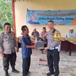 Kasat Lantas Polres Tapsel, AKP Danil Saragih, saat menyerahkan souvenir ke perwakilan masyarakat di sela gerakan Kapolres Tapsel Jelajah Huta