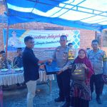 Kanit Regident Sat Lantas Polres Tapsel, Ipda Edy Sofyan Nasution, saat menyerahkan souvenir ke perwakilan masyarakat di sela gerakan Kapolres Jelajah Huta