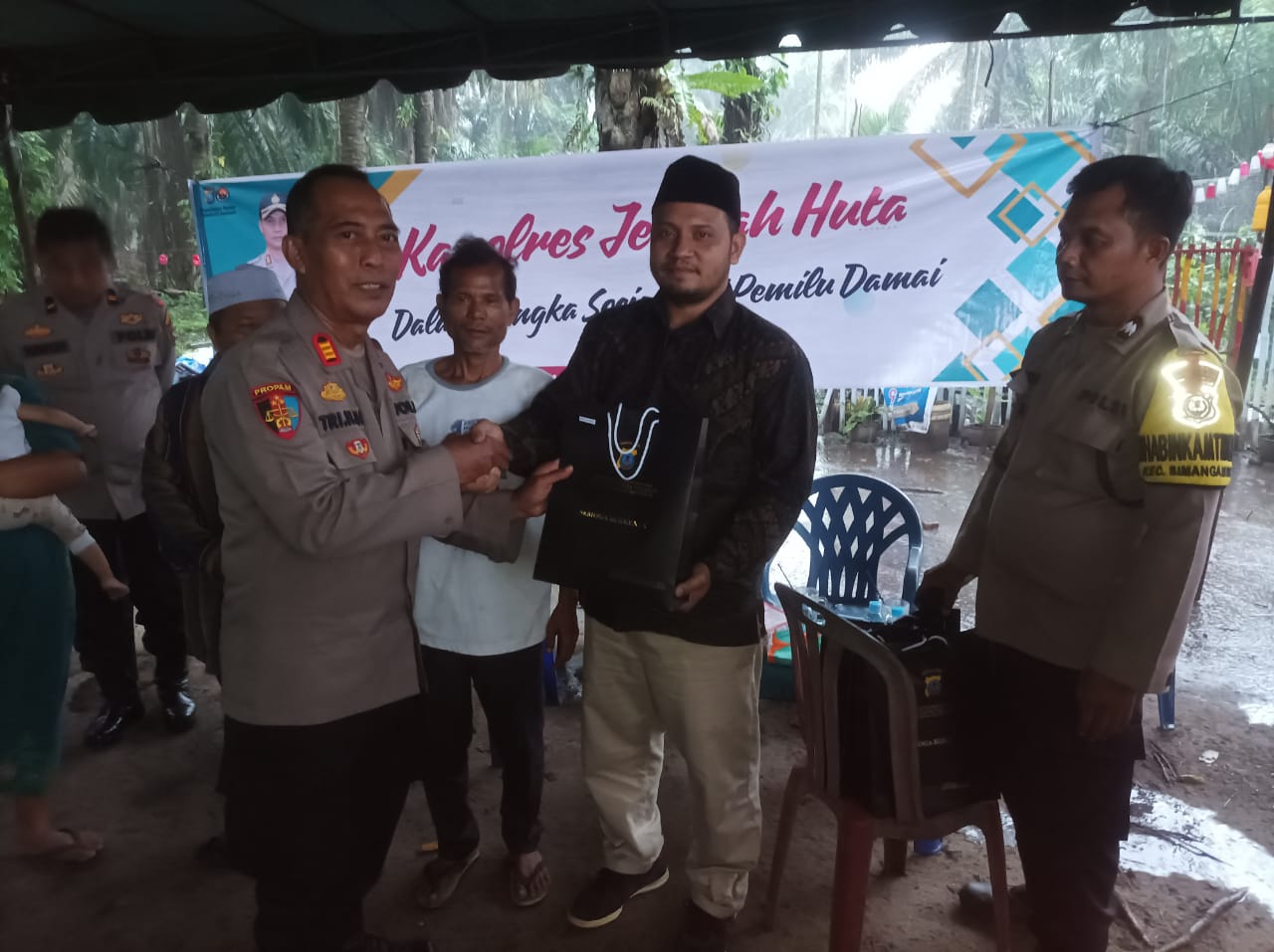 Kasi Propam Polres Tapsel, AKP R Triharjanto, saat berikan souvenir ke perwakilan masyarakat di sela gerakan Kapolres Jelajah Huta